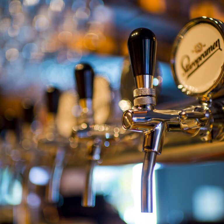 Focused image of a shiny beer tap in a stylish bar with a blurred background.